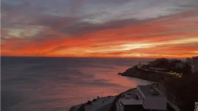 a sunset over a body of water with the sky at Comfortable and Elegant Seafront Apartment in Faro de Cullera