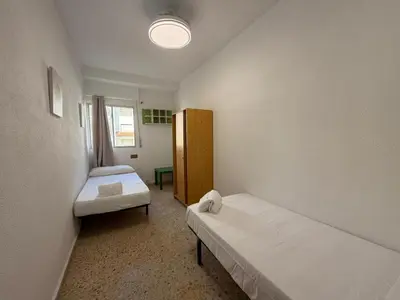 a small room with two beds and a window at Wimpy Solo Familias Serviplaya in Casas Las Basas