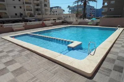a large swimming pool with a bench in a building at Wimpy Solo Familias Serviplaya in Casas Las Basas