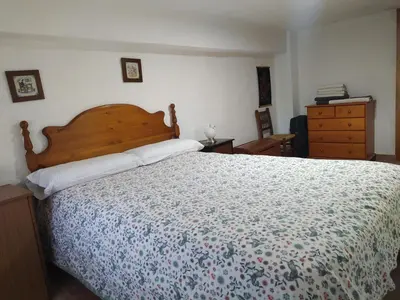 a small bedroom with a bed and a table at La caseta del llorer in Catadau