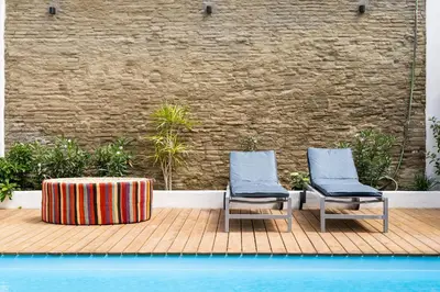 two chairs and a table sitting on a wooden deck at Maison avec piscine à Valencia in Valencia