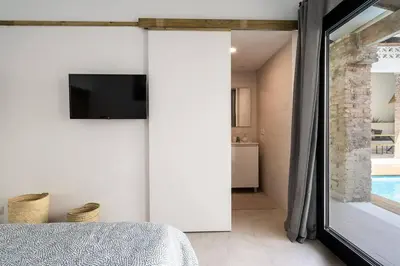 a bedroom with a sliding glass door leading to a bathroom at Maison avec piscine à Valencia in Valencia