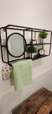 a black shelf with two towels and a mirror at CasaJulis Chelva in Chelva