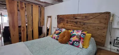 a bedroom with a bed with a wooden headboard at CasaJulis Chelva in Chelva