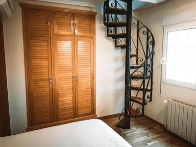 a spiral staircase in a room with a bedroom at Casa Cosy in Serra