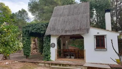 a small white house with a thatched roof at Casa Cosy in Serra