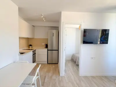 a kitchen with white cabinets and a refrigerator at NUEVO, primera linea de playa, con piscina y vistas al mar in Cullera