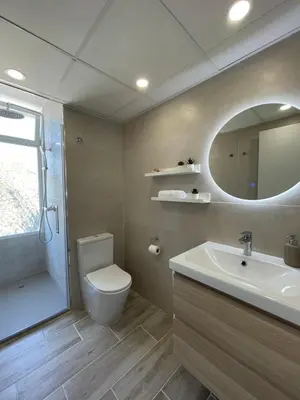 a bathroom with a toilet and a sink and a mirror at NUEVO, primera linea de playa, con piscina y vistas al mar in Cullera