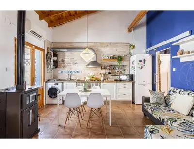 a kitchen and living room with a table and chairs at Casita Mona y Acogedora in Alaquas
