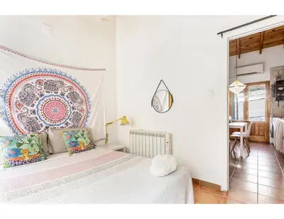 a white bedroom with a bed with a large mandala on the wall at Casita Mona y Acogedora in Alaquas