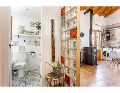 a bathroom with a toilet and a kitchen at Casita Mona y Acogedora in Alaquas