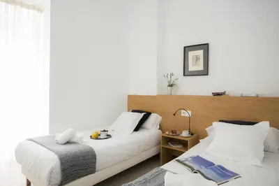 a bedroom with two beds and a table with a lamp at SingularStays Mar44 in Valencia