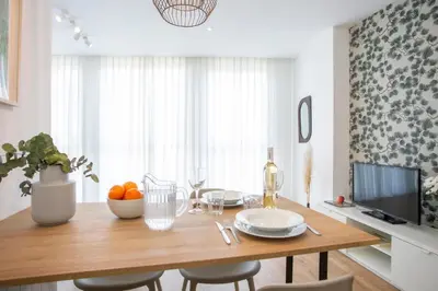 a dining room with a wooden table and a television at SingularStays Mar44 in Valencia