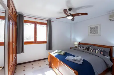 a bedroom with a bed and a ceiling fan at VILLA LATEL in Serra
