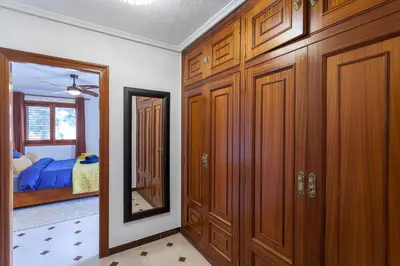 a bedroom with wooden cabinets and a mirror and a bed at VILLA LATEL in Serra