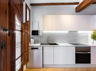 a kitchen with white cabinets and a sink at Beautiful restored house with terrace in Valencia