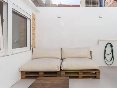 a couch sitting in a room next to a window at Beautiful restored house with terrace in Valencia