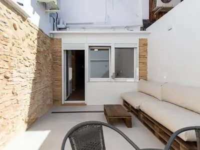 a living room with a couch and a table at Beautiful restored house with terrace in Valencia