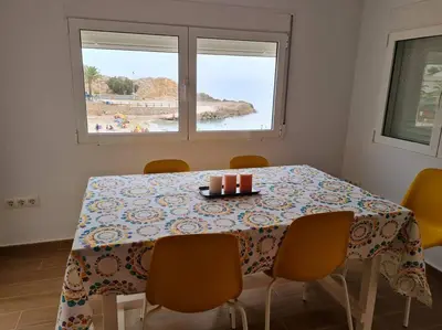 a dining room table with chairs and a table with candles at The perfect holiday apartment with fantastic views in Faro de Cullera