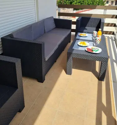 a patio with a couch and a table with food on it at The perfect holiday apartment with fantastic views in Faro de Cullera