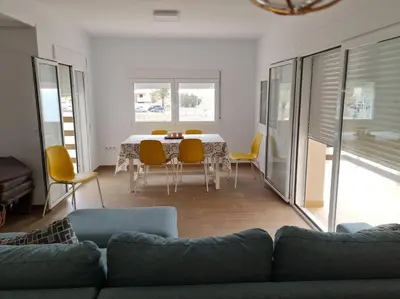 a living room with a couch and a table and chairs at The perfect holiday apartment with fantastic views in Faro de Cullera