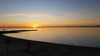 a sunset on the beach with a person on a bike at Primera linea - Descanso Sol y Mar in Cullera