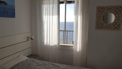 a bedroom with a window with a view of the ocean at Primera linea - Descanso Sol y Mar in Cullera
