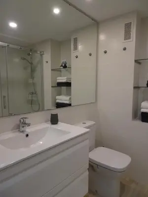 a white bathroom with a sink and a toilet at Primera linea - Descanso Sol y Mar in Cullera