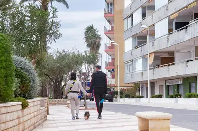 two people walking down a street with a dog at Tranquilidad a 2 minutos del mar in Canet de Berenguer