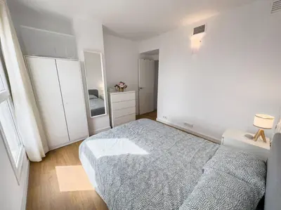 a white bedroom with a bed and a mirror at Tranquilidad a 2 minutos del mar in Canet de Berenguer