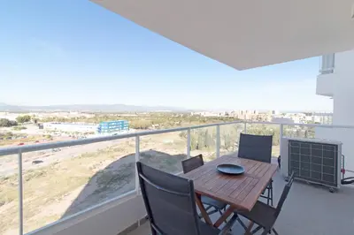 a dining table and chairs on a balcony with a view at Global Vacacional, Apartamento con terraza y vistas al mar y a la montaña in Canet de Berenguer