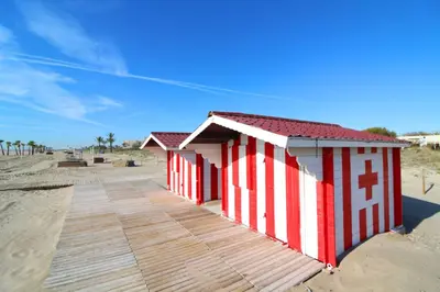 a row of beach huts on the beach at Global Vacacional, Apartamento con terraza y vistas al mar y a la montaña in Canet de Berenguer