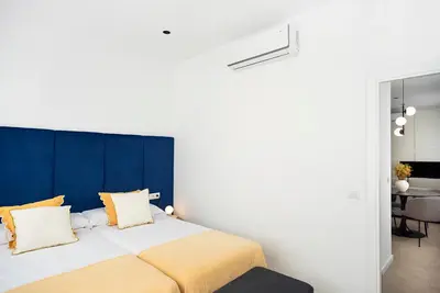 a bedroom with a large bed with a blue headboard at Blanq Marina Suites in Valencia