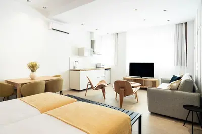 a bedroom with two beds and a living room at Blanq Marina Suites in Valencia