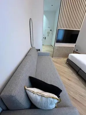 a living room with a gray couch with a pillow at Blanq Marina Suites in Valencia