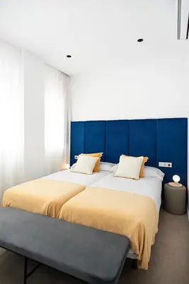 two beds sitting next to each other in a bedroom at Blanq Marina Suites in Valencia