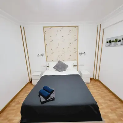 a bedroom with a large bed with blue pillows on it at Pintor 31 in Valencia