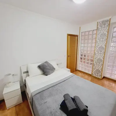 a bedroom with a white bed with a gray rug at Pintor 31 in Valencia