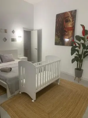 a white crib in a room with a bedroom at Exquisite studio apartment with an original design in Valencia