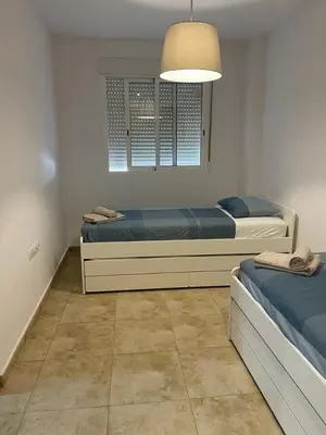a bedroom with two beds and a window at UIM Mediterraneo Felipe 6 Wifi in Puerto de Sagunto