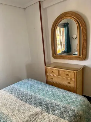 a bedroom with a dresser and a mirror and a bed at Casa Schila in Tavernes de Valldigna