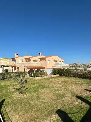 a large house with a yard in front of it at Oasis en la playa: piscina y relax in Cullera