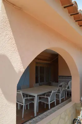 a table and chairs on the balcony of a house at Oasis en la playa: piscina y relax in Cullera