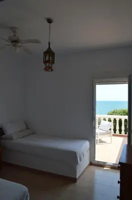 a bedroom with a bed and a view of the ocean at Oasis en la playa: piscina y relax in Cullera