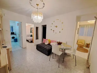 a living room with a table and a chandelier at Apartamento acogedor con wifi in Valencia