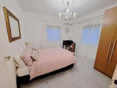 a bedroom with a pink bed and a chandelier at Apartamento acogedor con wifi in Valencia