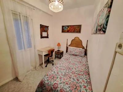 a bedroom with a bed and a desk and a window at Apartamento acogedor con wifi in Valencia