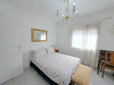 a white bedroom with a bed and a chandelier at Apartamento acogedor con wifi in Valencia