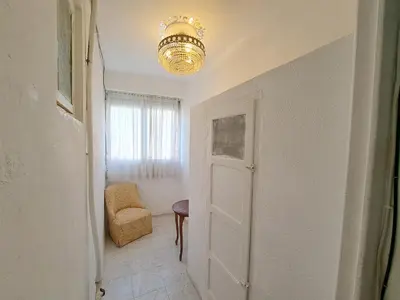 a hallway with a door and a chair and a chandelier at Apartamento acogedor con wifi in Valencia