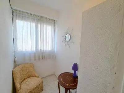 a living room with a chair and a table at Apartamento acogedor con wifi in Valencia